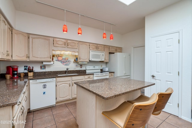 kitchen featuring white appliances, light tile patterned floors, a kitchen island, decorative light fixtures, and a sink