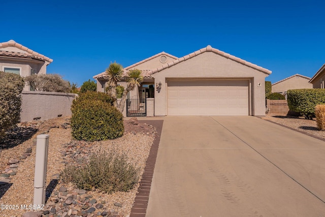 view of front of house featuring driveway, an attached garage, a tile roof, and stucco siding