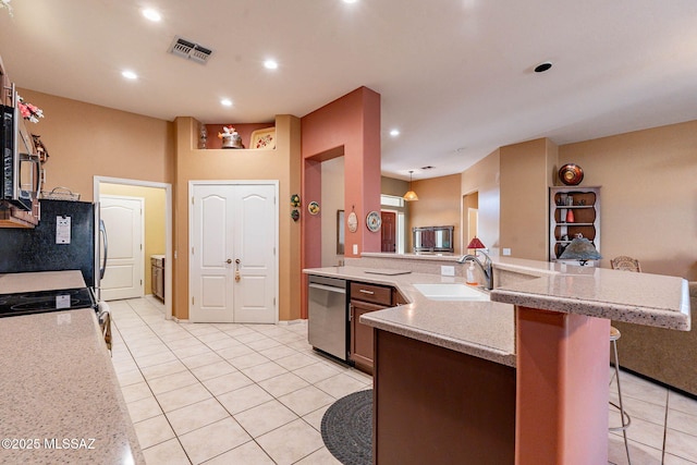 kitchen with a breakfast bar, stainless steel appliances, recessed lighting, visible vents, and a sink