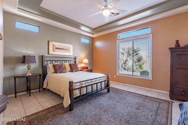 bedroom with a raised ceiling, baseboards, and light tile patterned floors