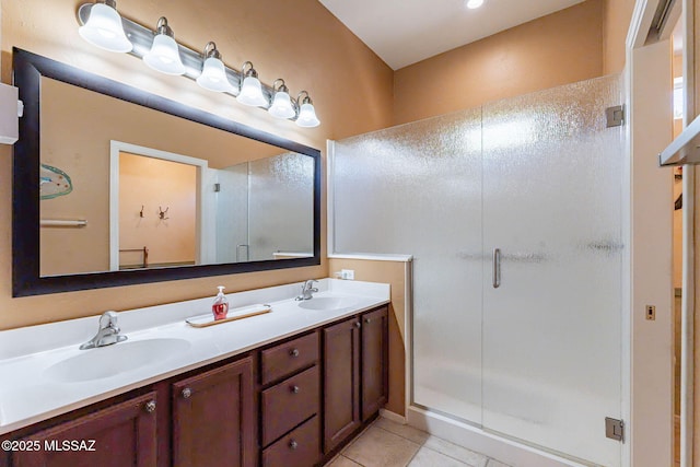 bathroom featuring tile patterned floors, a sink, a shower stall, and double vanity