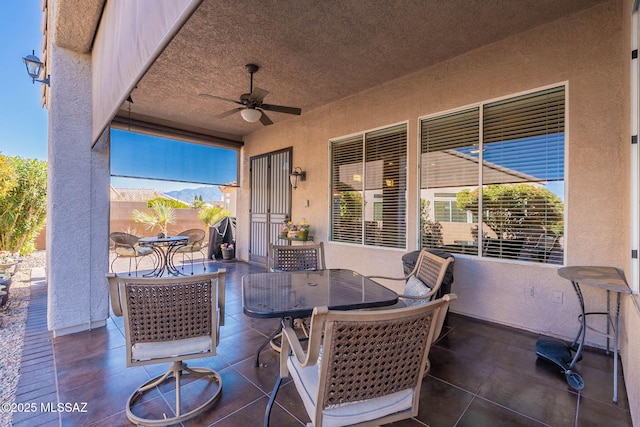 view of patio / terrace with a ceiling fan, outdoor dining area, and fence