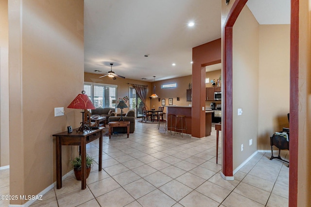 living area with recessed lighting, ceiling fan, baseboards, and light tile patterned floors