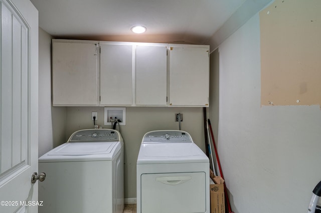 clothes washing area with washing machine and dryer and cabinet space