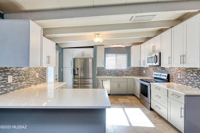 kitchen with tasteful backsplash, visible vents, appliances with stainless steel finishes, beamed ceiling, and a sink