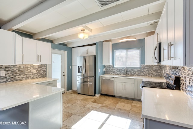 kitchen featuring tasteful backsplash, beam ceiling, appliances with stainless steel finishes, and a sink