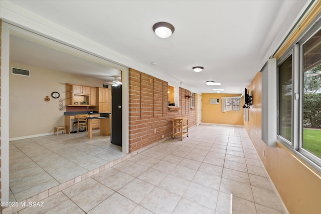 interior space featuring light tile patterned floors, visible vents, and baseboards