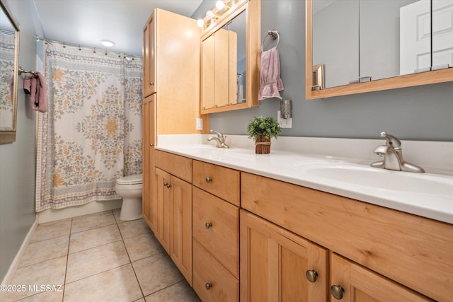 full bath with a sink, toilet, double vanity, and tile patterned floors