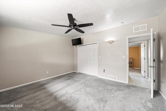 unfurnished bedroom featuring visible vents, carpet floors, a closet, and a ceiling fan