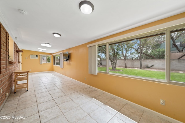 empty room with light tile patterned floors and baseboards