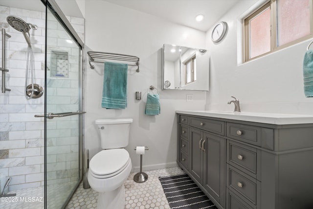 full bathroom featuring tiled shower, toilet, vanity, and baseboards