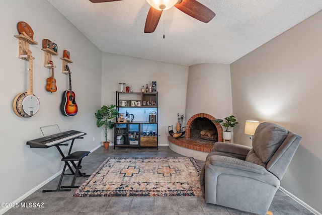 living area featuring baseboards, lofted ceiling, ceiling fan, a textured ceiling, and a brick fireplace