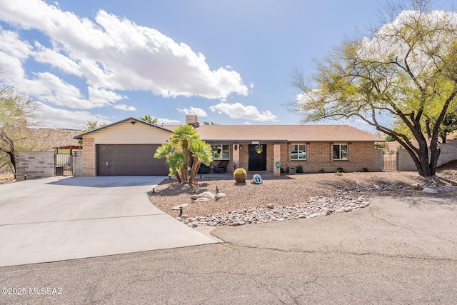 single story home featuring brick siding, concrete driveway, a gate, fence, and a garage