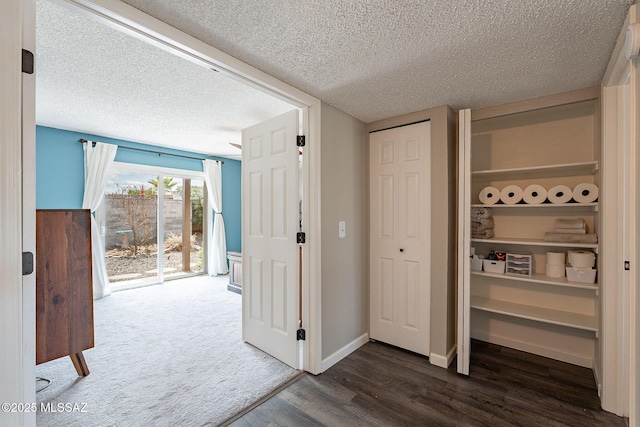 interior space with baseboards, dark wood finished floors, and a textured ceiling