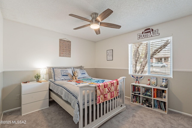 carpeted bedroom with a ceiling fan, a textured ceiling, and baseboards