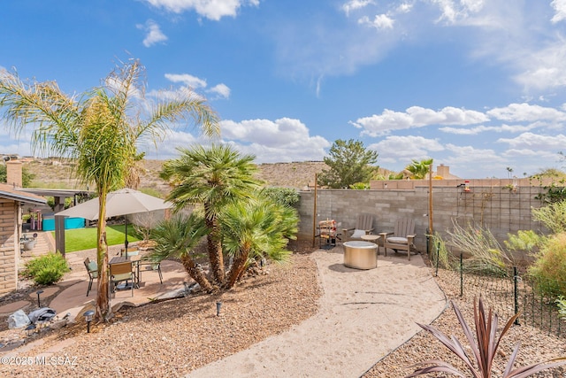 view of yard featuring a patio area, an outdoor fire pit, and a fenced backyard