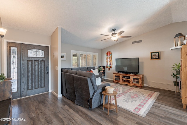 living area featuring lofted ceiling, a textured ceiling, visible vents, a ceiling fan, and dark wood-style floors