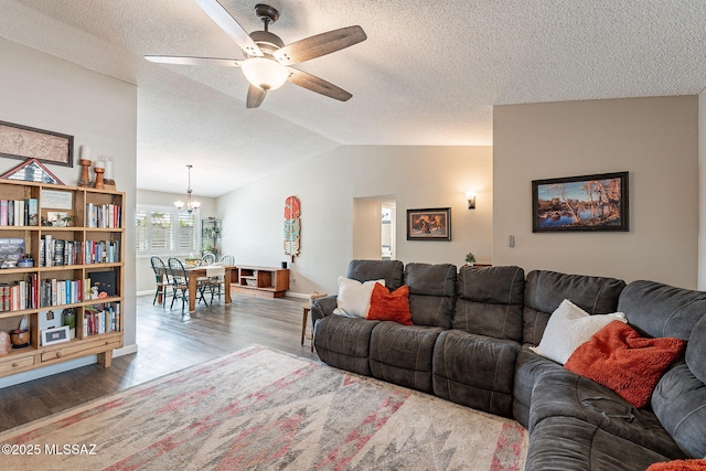 living room with vaulted ceiling, a textured ceiling, ceiling fan with notable chandelier, and wood finished floors