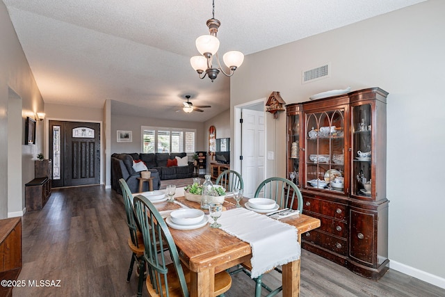 dining room with baseboards, visible vents, wood finished floors, a textured ceiling, and ceiling fan with notable chandelier