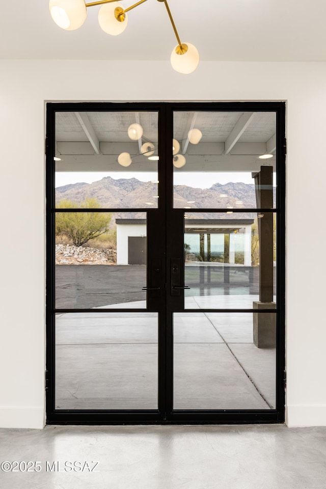 doorway to outside featuring french doors, baseboards, and a mountain view