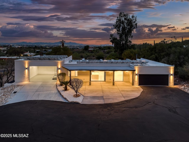 view of front of property featuring concrete driveway, an attached garage, and stucco siding