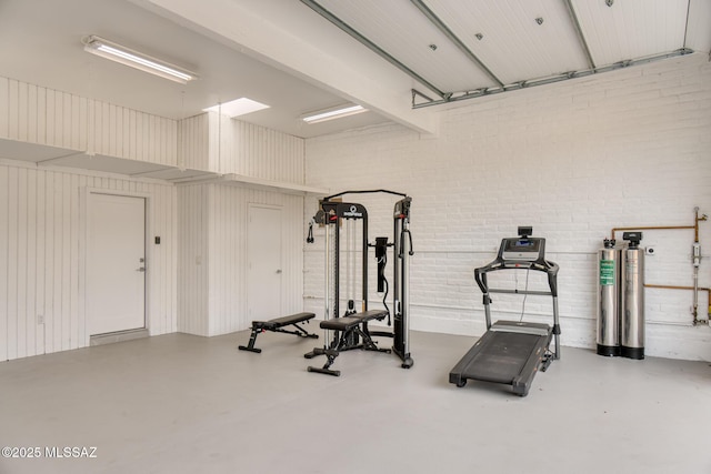 exercise room featuring brick wall