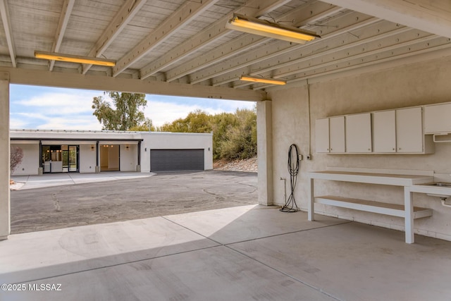 view of patio / terrace featuring an attached garage and driveway