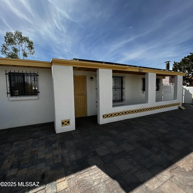 back of house featuring stucco siding and a patio