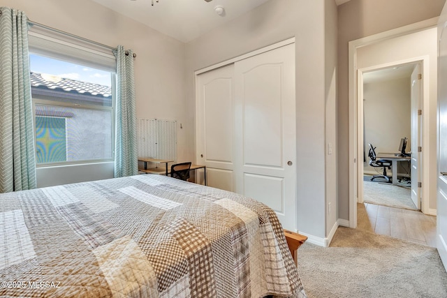 carpeted bedroom featuring a closet and baseboards