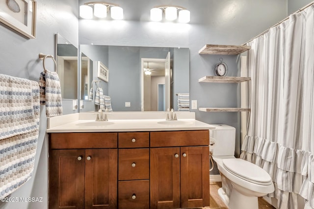 full bathroom featuring double vanity, a sink, toilet, and a ceiling fan