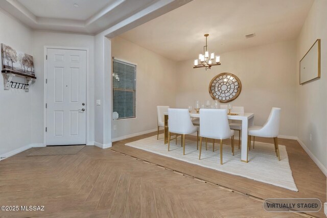 foyer featuring visible vents, parquet flooring, baseboards, and an inviting chandelier