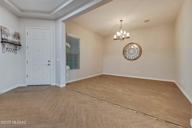 entrance foyer featuring visible vents, baseboards, a notable chandelier, and parquet floors