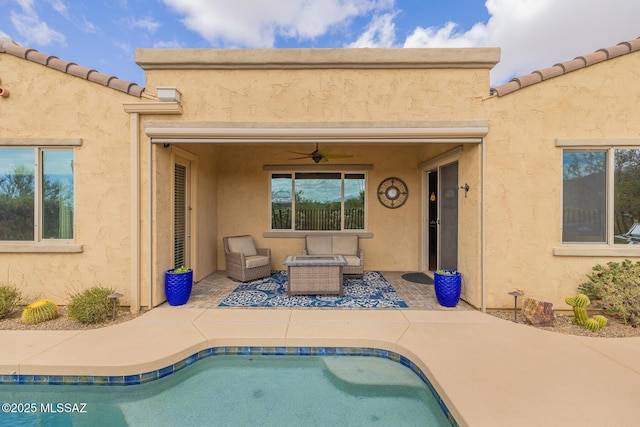 outdoor pool with ceiling fan and a patio