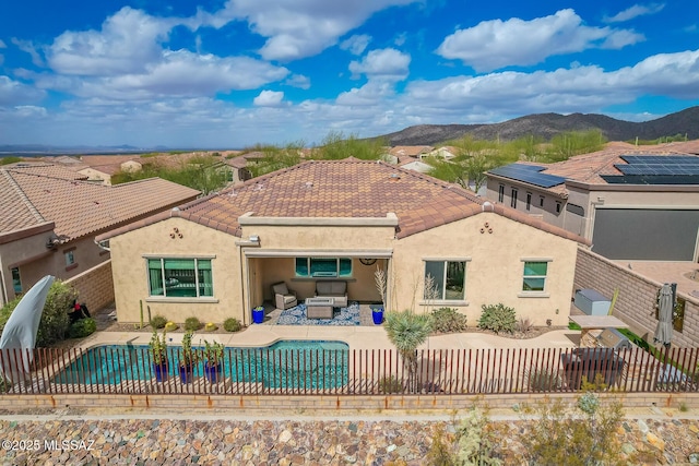 rear view of property featuring a patio area, outdoor lounge area, a fenced backyard, and a mountain view