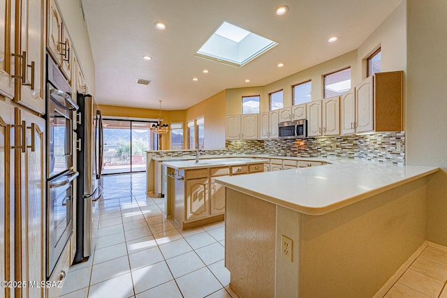 kitchen featuring a peninsula, appliances with stainless steel finishes, a kitchen island, and light countertops