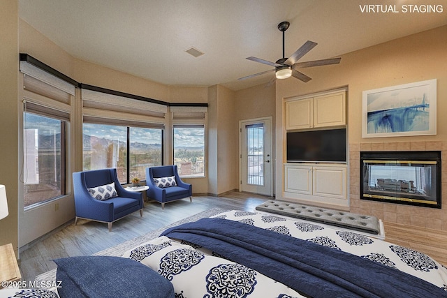 bedroom featuring a fireplace, light wood finished floors, visible vents, vaulted ceiling, and access to outside