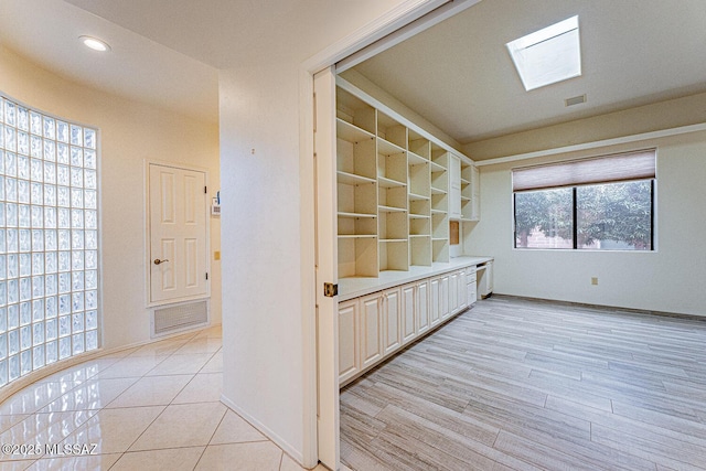 interior space featuring a skylight, recessed lighting, visible vents, light wood-style flooring, and baseboards