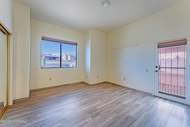 spare room featuring light wood-type flooring and a wealth of natural light