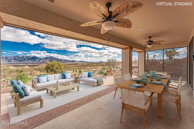 view of patio with a ceiling fan, fence, a mountain view, outdoor lounge area, and outdoor dining space