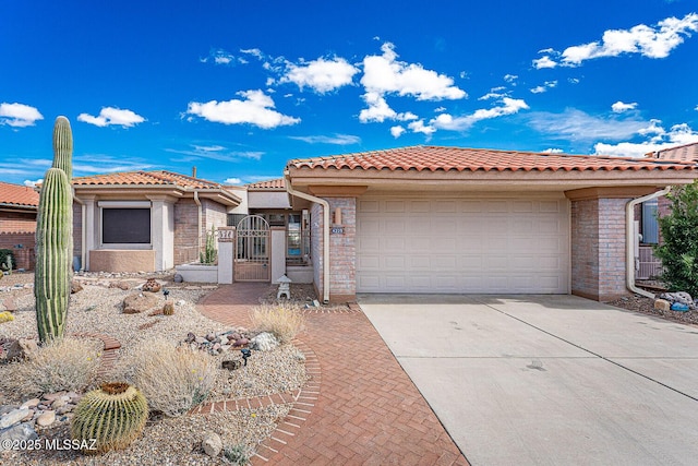 view of front of home with an attached garage, a gate, concrete driveway, and a tiled roof