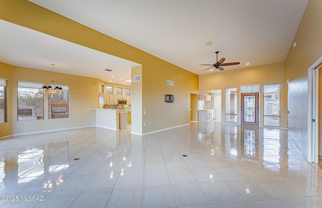 empty room featuring light tile patterned floors, visible vents, baseboards, and ceiling fan with notable chandelier