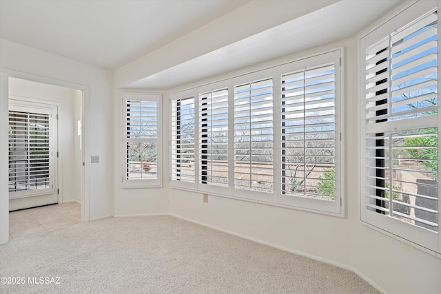 spare room with light colored carpet and baseboards