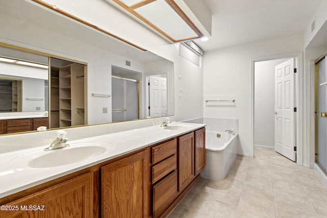 bathroom featuring a garden tub, double vanity, a sink, and a shower stall