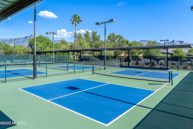 view of sport court featuring community basketball court, a mountain view, and fence