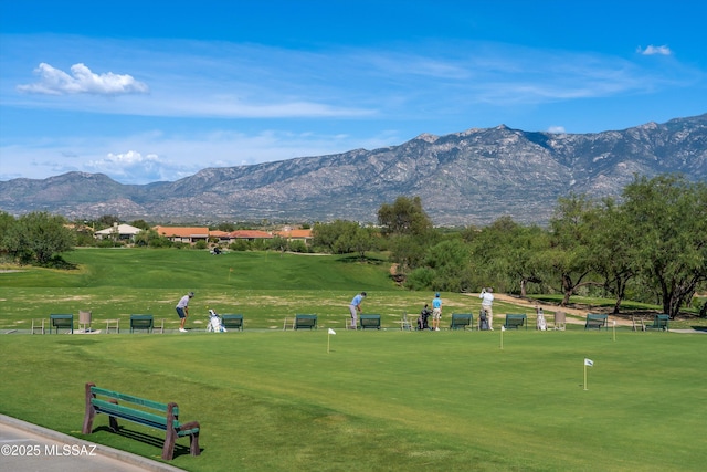 surrounding community with view of golf course, a lawn, and a mountain view