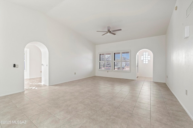 spare room featuring a ceiling fan, arched walkways, high vaulted ceiling, and light tile patterned floors