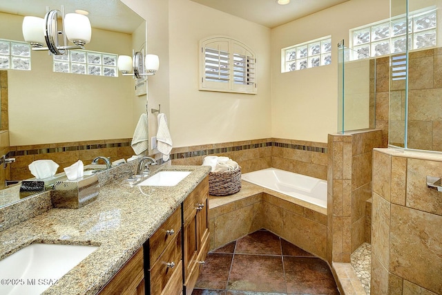 bathroom with double vanity, tile patterned flooring, a sink, and a bath