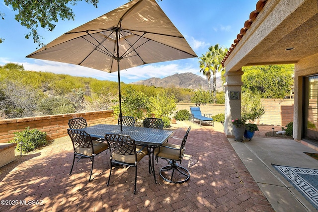 view of patio featuring a fenced backyard, a mountain view, and outdoor dining space