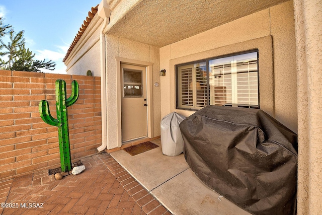 property entrance with a tiled roof and stucco siding