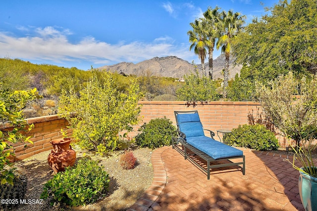 view of patio with a mountain view and fence